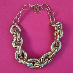 Bold, silver-toned piece is a chunky articulated link statement necklace.